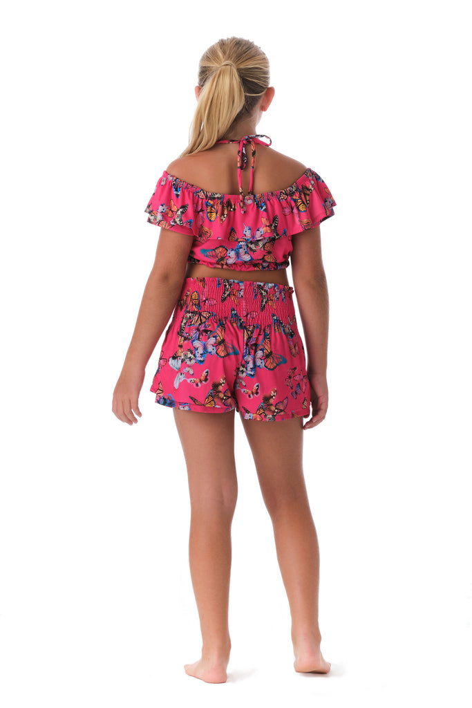 Girl is wearing Submarine Designer Swimwear Top Notch fly away pink print off-the-shoulder ruffled top.